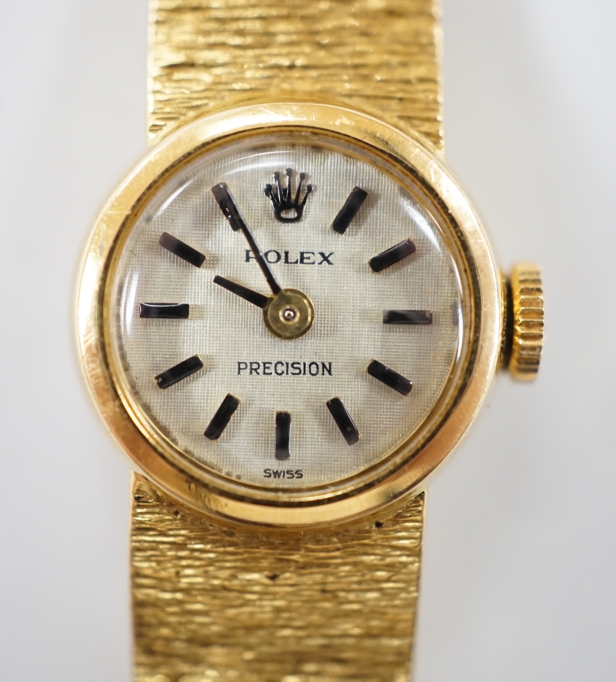 A lady's textured 750 yellow metal Rolex manual wind wrist watch, on integral bracelet, no box or papers, case diameter 15mm